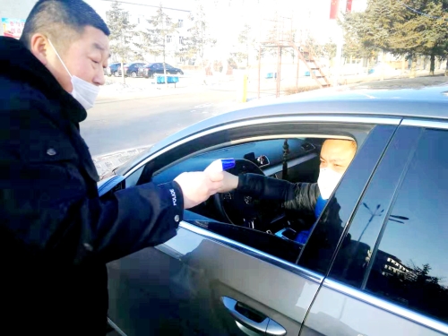 图为东荣二矿保卫科干警严格检查进出矿车辆，，，，，对每名进矿职工都进行体温测量并登记。。。。。。